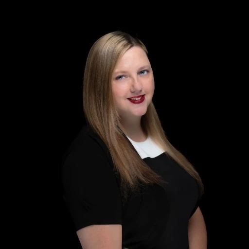 Marlo Cabanillas, realtor, smiling in a black top with a white collar.