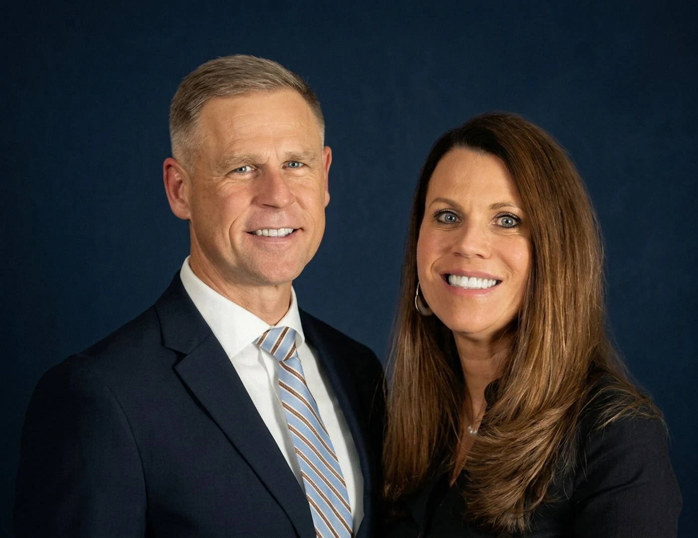 Pastor Gunkel and his wife smiling together against a dark blue background.